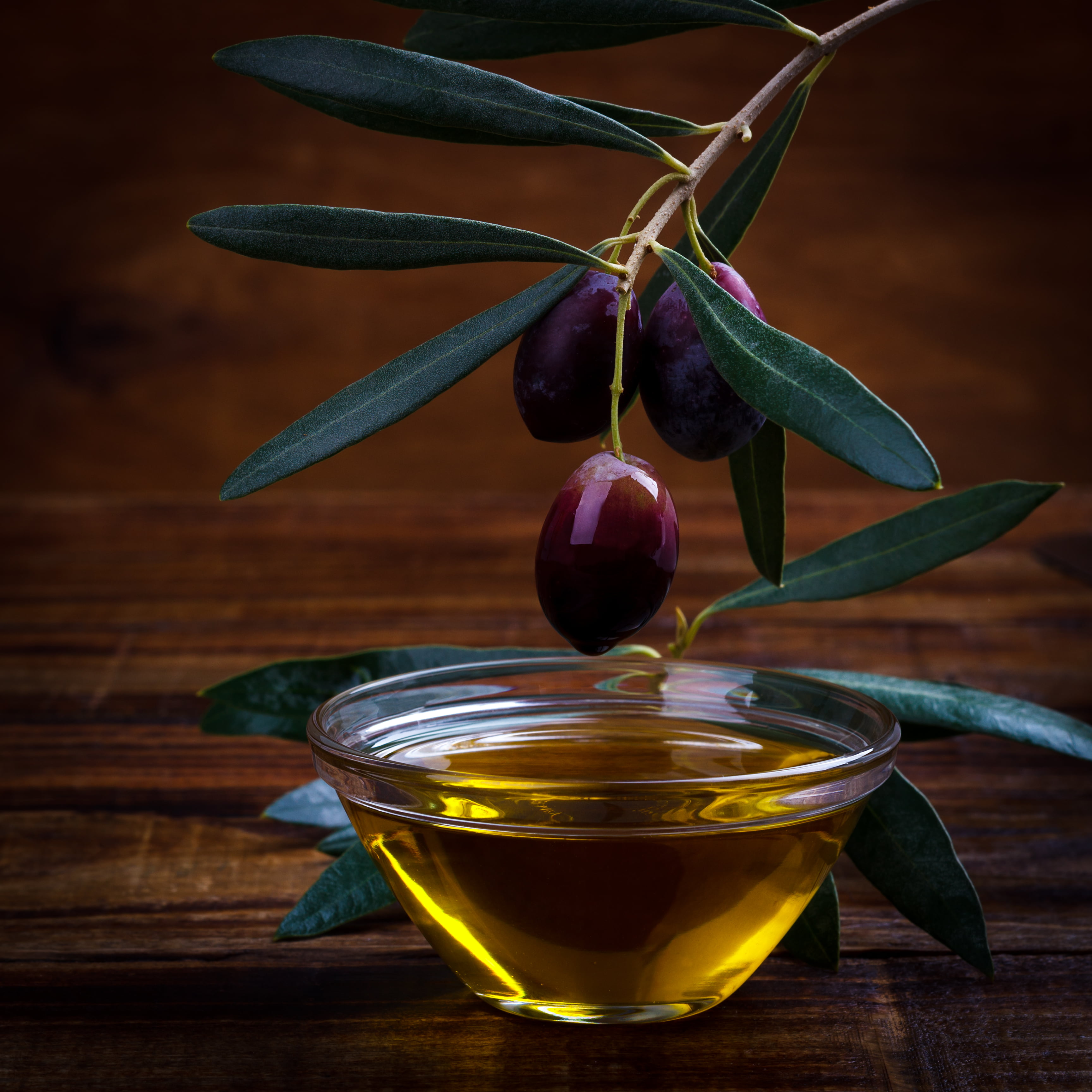 Aceite de Oliva Virgen Extra vertiéndose sobre una ensalada fresca, resaltando beneficios saludables y uso diario en la cocina mediterránea